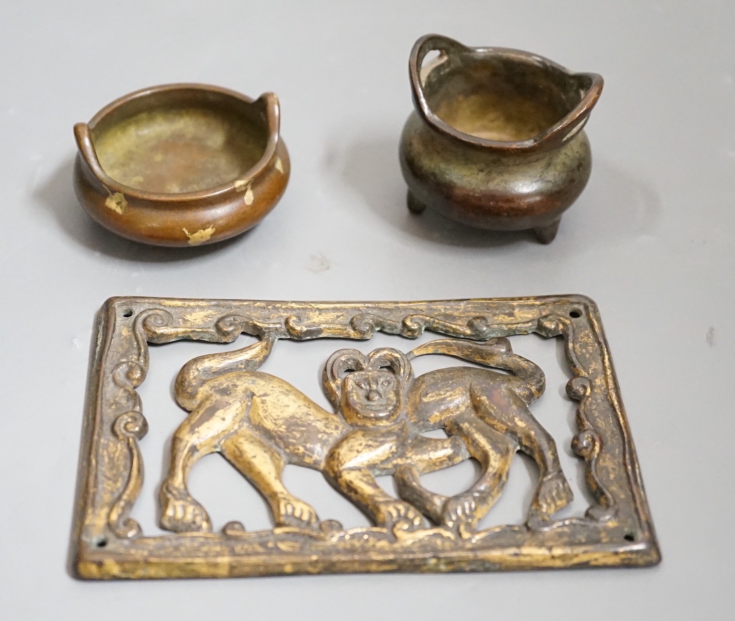 Two small bronze two handled censers and an Ordos style pierced bronze monkey panel, 13cms wide
